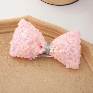 Gros plan pince à cheveux nœud paillettes rose, accessorio brillant pour jolies filles.
