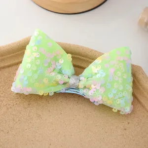 Gros plan détaillé de la jolie pince à cheveux nœud à sequins scintillants et colorés.