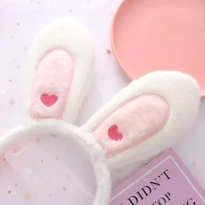 Cute plush bunny ear headband with pink heart embroidery, soft fluffy material for daily style.