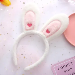 Closeup detail of cute plush bunny ear headband with sweet pink embroidered hearts.
