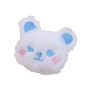Simpatico cerotto in peluche di orso bianco soffice con dettagli blu e cuori rosa per decorazione.