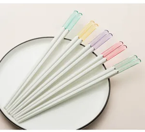 Primo piano di punte per bacchette colorate traslucide, elegante corpo bianco, stoviglie