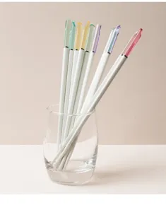 Primo piano dettagliato di bacchette in lega con punte in cristallo colorato in un bicchiere.