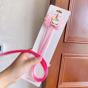 Detailed view of kids gradient pink hair extension with glitter unicorn bow clip accessory.