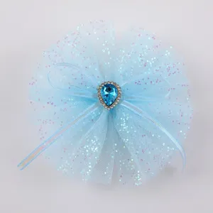 Vista dettagliata del fiocco per capelli in tulle glitterato azzurro con cristallo strass.