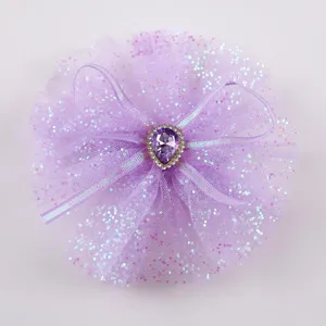 Primo piano dettaglio del fermaglio per capelli con fiocco in tulle viola e strass di cristallo.