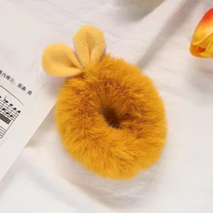Close up of a cute yellow plush bunny ear hair scrunchie, soft fluffy texture detail view.