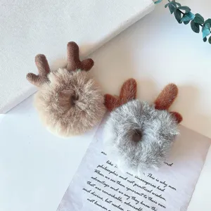 Plush deer antler hair scrunchie detail view, soft fuzzy texture winter hair accessory.