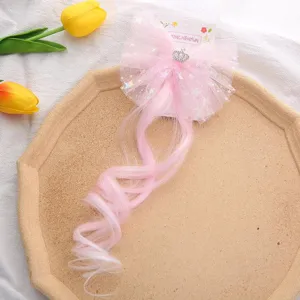 Vue de détail extension cheveux bouclés nœud maille rose enfant, princesse fête.