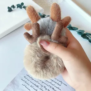 Plush reindeer hair tie detail, soft fluffy material close up, cute winter hair accessory.