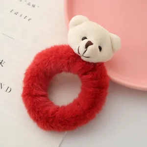 Vista dettagliata del fermacapelli con orsetto di peluche rosso, accessorio morbido.