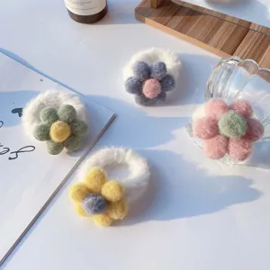 Nahaufnahme des flauschigen Blumen-Haargummis, weiche Bonbonfarben für süßen Herbst-Haarstyle.