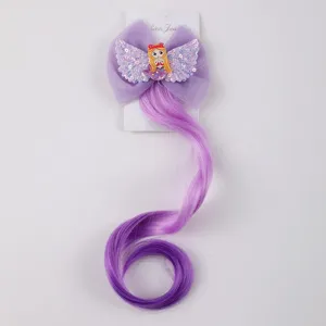 Detail shot of children purple gradient curly hair clip with glitter mermaid wing bows.
