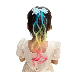Close-up detail of colorful gradient wig hair extension with sparkling glitter blue bow clip.