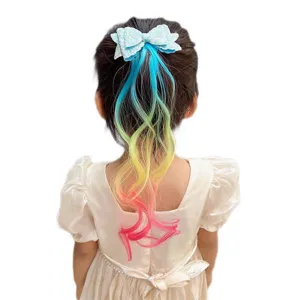Detailed shot of children's colorful gradient hair extension with cute glitter bow hair clip.
