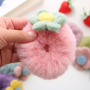 Close-up detail of fluffy pink plush flower hair scrunchie, soft winter hair accessory