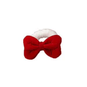Close-up detail of the red velvet bow hair clip featuring soft white plush trim design.