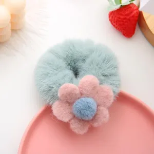 Close-up view of the fluffy plush floral hair scrunchie, featuring pastel green and pink texture.