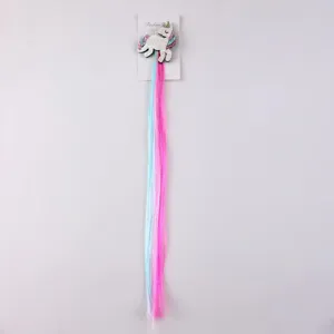 Close-up detail of cute unicorn hair clip with long colorful extensions for kids styling.