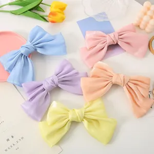 Close-up detail of colorful satin bow hair clips, elegant handmade hair accessories for daily wear.
