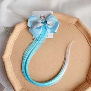 Detail view of gradient hair extension clip with blue bow and crystal heart charm.
