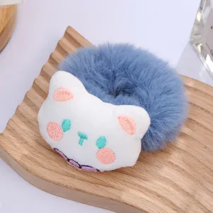 Primo piano dettagliato dell'elastico per capelli in peluche blu con gatto bianco.