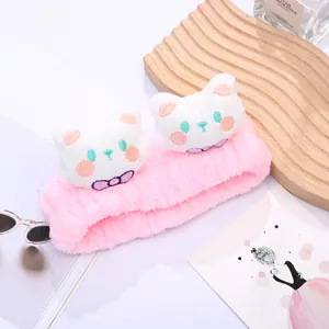 Detailed view of pink plush cat facial headband, soft fluffy fabric with cute cat ears and bow.