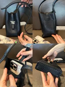 Vue détaillée du sac bandoulière noir en cuir texturé montrant la structure compacte et la sangle.