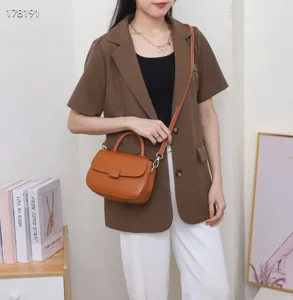 Detail view of the vintage brown leather handbag, showing flap design and fine stitching details.