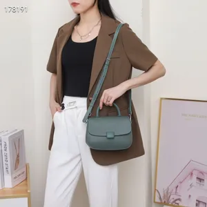 Green leather top handle bag detail shot, showing exquisite flap design and textured grain.