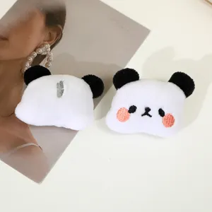 Cute panda plush hair accessory detail showcasing soft white fabric and embroidered face.