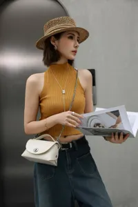 Detalle de bolso de hombro tipo sobre de piel elegante, diseño chic para mujeres.