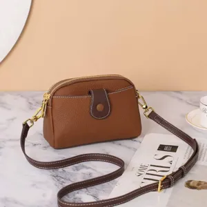 Detailed view of brown Togo leather crossbody bag, stylish casual genuine leather shoulder bag.