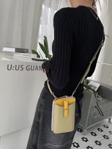 Vista di dettaglio della mini borsa tracolla per telefono in vera pelle bicolore.