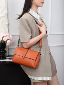 Stylish orange leather shoulder bag detail shot, featuring a flap design and sleek strap for women.