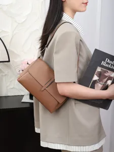 Classic brown leather shoulder bag detail, stylish women crossbody bag with metal buckle.