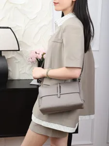 Grey leather crossbody shoulder bag detail showcasing premium texture and elegant metal hardware.