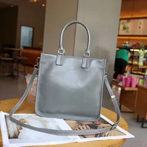 Detailansicht der minimalistischen grauen Ledertasche, elegante Textur und Kontrastnähte.