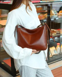 Detailed shot of the retro brown leather shoulder bag, highlighting texture and craft.