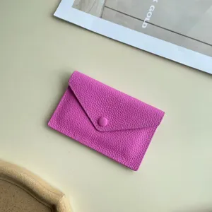 Porte-monnaie enveloppe en cuir rose, étui à cartes minimaliste avec bouton, format compact.