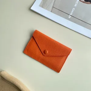 Vue détaillée du porte-monnaie en cuir orange, gros plan d'étui de carte minimaliste.