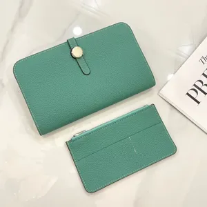 Detail view of green leather passport holder and card wallet set, elegant pebble grain texture.