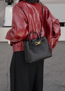 Dettaglio della borsa in pelle intrecciata, con elegante chiusura a nodo in metallo.