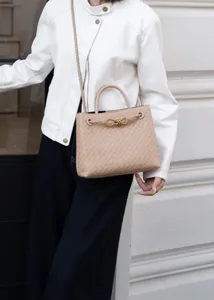 Dettaglio della borsa a mano intrecciata, elegante shopper con preziosa fibbia in metallo.