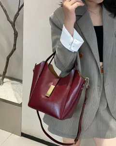 Détail du sac seau en cuir bordeaux pour femme, élégant sac porté épaule avec fermoir en métal.