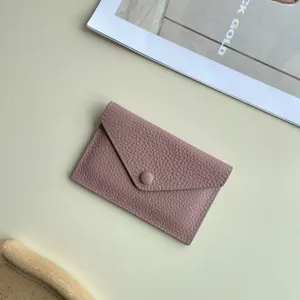 Vue détaillée du porte-monnaie minimaliste en cuir véritable avec fermeture à bouton-pression.