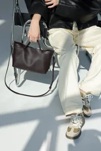 Detailed shot of dark brown leather shoulder bag, premium texture and stylish everyday design.