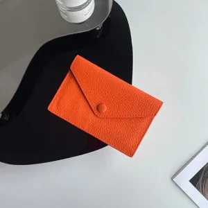 Porte-carte enveloppe minimaliste en cuir orange, petit porte-monnaie souple détail élégant.