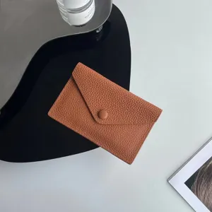 Détail de porte-monnaie minimaliste en cuir marron, étui compact pour cartes et quotidien.