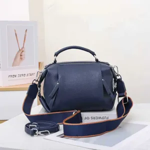 Detail view of genuine leather women handbag, navy blue daily commute top handle shoulder bag.